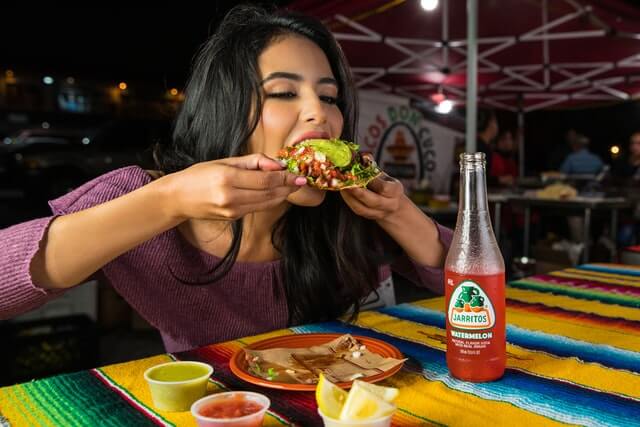 Woman enjoying a tostada in a Mexican restaurant