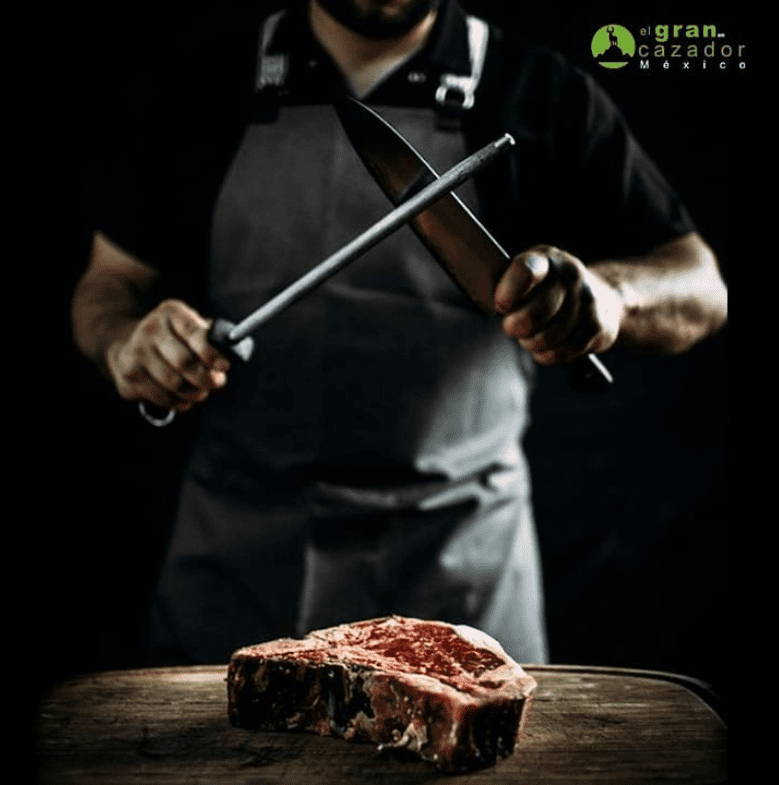 a man holding a bat on top of a wooden cutting board